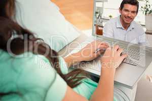 Composite image of smiling man using digital tablet at home