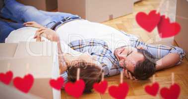 Composite image of cute couple lying on the floor