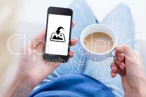 Composite image of woman using her mobile phone and holding cup
