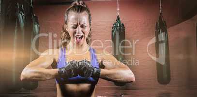 Composite image of aggressive female boxer flexing muscles