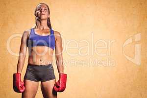 Composite image of female athlete standing with gloves
