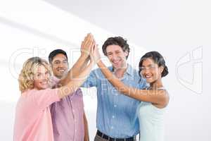 Composite image of  casual business team high fiving