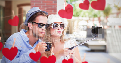 Composite image of cute couple taking a selfie with selfie stick