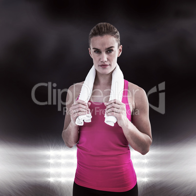 Composite image of muscular woman holding a towel around her nec