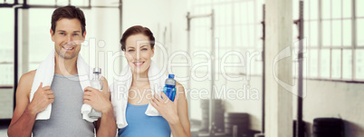 Composite image of portrait of a happy fit couple with water bot