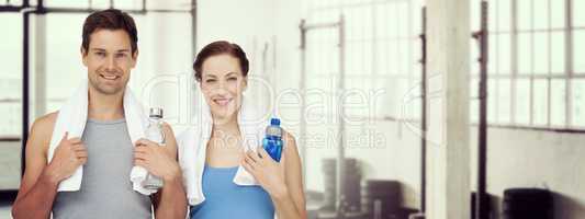 Composite image of portrait of a happy fit couple with water bot