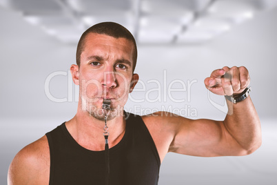 Composite image of portrait of attentive trainer blowing his whi