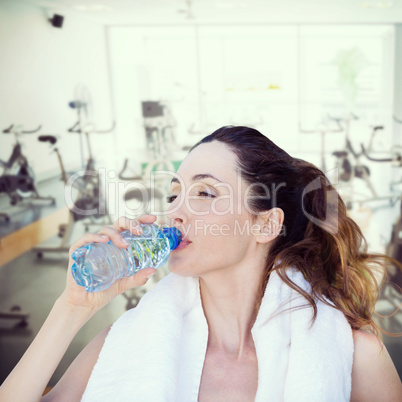 Composite image of beautiful brunette drinking water