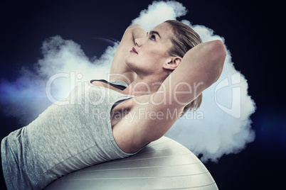 Composite image of muscular woman doing sit ups on exercise ball