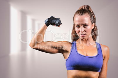 Composite image of portrait of confident woman flexing muscles