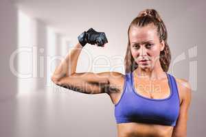 Composite image of portrait of confident woman flexing muscles