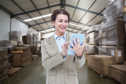 Composite image of smiling businesswoman using tablet computer