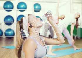 Composite image of sporty blonde drinking water