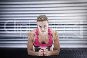 Composite image of  a muscular woman on a plank position