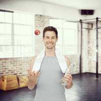 Composite image of smiling fit young man with apple and water bo