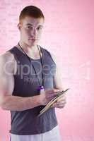 Composite image of fit personal trainer writing on clipboard