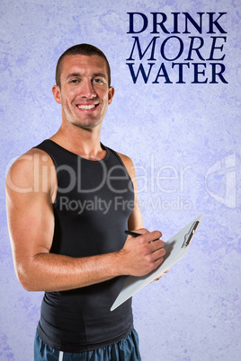Composite image of smiling sports coach writing on clipboard