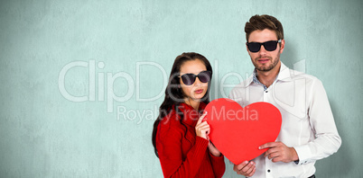 Composite image of portrait of couple with sunglasses holding pa