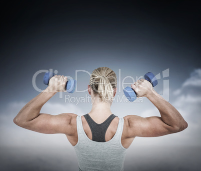 Composite image of  muscular woman working out with dumbbells