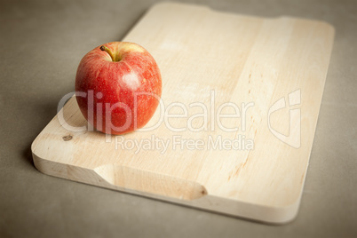 apple on wooden cutting board