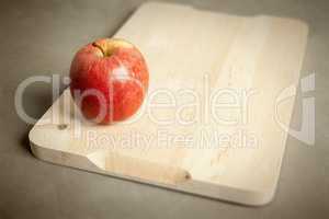 apple on wooden cutting board