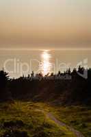 Path leading towards sunlight reflected in water under hazy hori