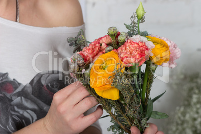 Florist making bright orange and pink bouquet