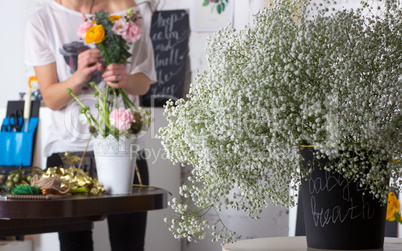 Florist making bright orange and pink bouquet