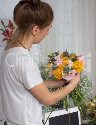 Florist looking at the bouquet of pastel color flowers