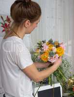 Florist looking at the bouquet of pastel color flowers