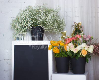 Three black buskets with flowers and black desk