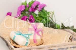Two pieces of soap with a basket with a bows , flowers and towel