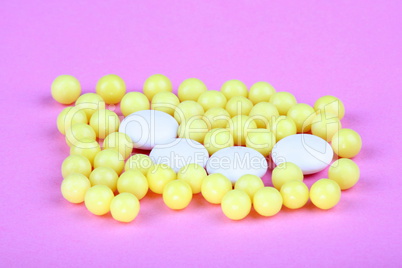 yellow vitamins on pink background