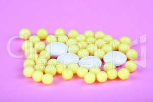 yellow vitamins on pink background