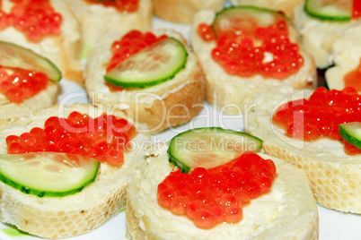 sandwiches with red caviar and piece of cucumber