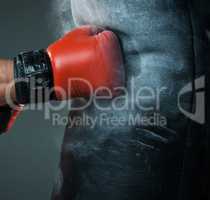 Hand  of boxer and punching bag over black background