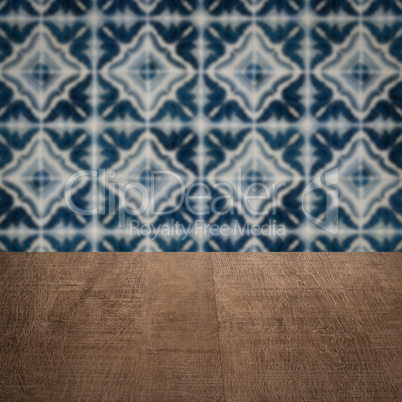 Wood table top and blur vintage ceramic tile pattern wall