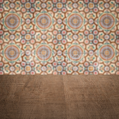 Wood table top and blur vintage ceramic tile pattern wall