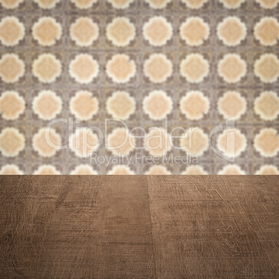 Wood table top and blur vintage ceramic tile pattern wall