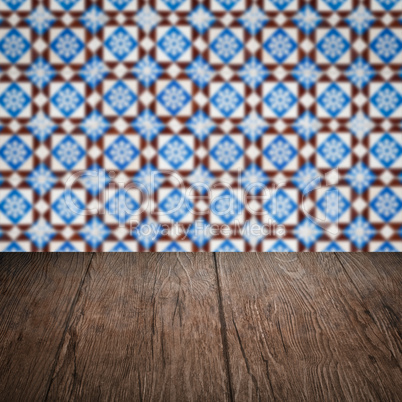 Wood table top and blur vintage ceramic tile pattern wall