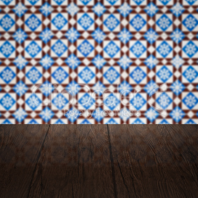 Wood table top and blur vintage ceramic tile pattern wall Wood table top and blur vintage ceramic tile pattern wall