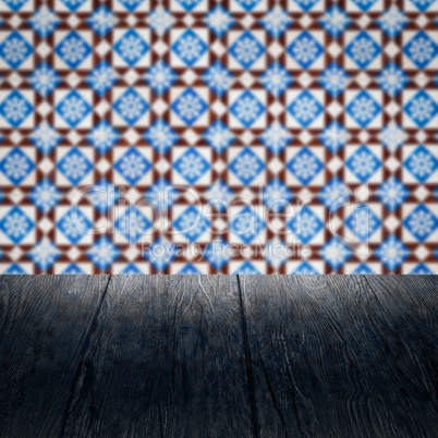 Wood table top and blur vintage ceramic tile pattern wall