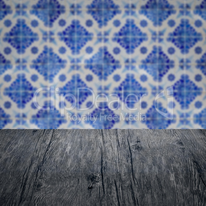 Wood table top and blur vintage ceramic tile pattern wall