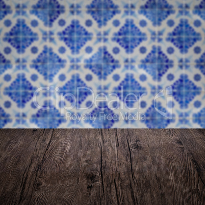 Wood table top and blur vintage ceramic tile pattern wall