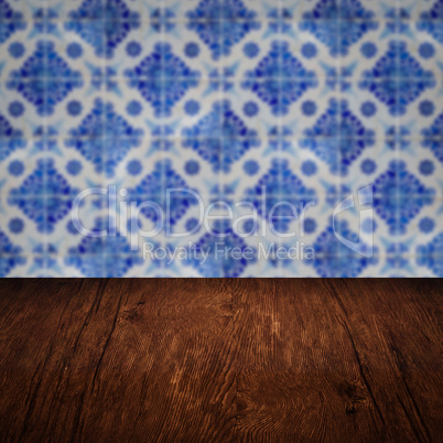 Wood table top and blur vintage ceramic tile pattern wall