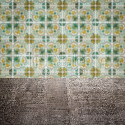 Wood table top and blur vintage ceramic tile pattern wall