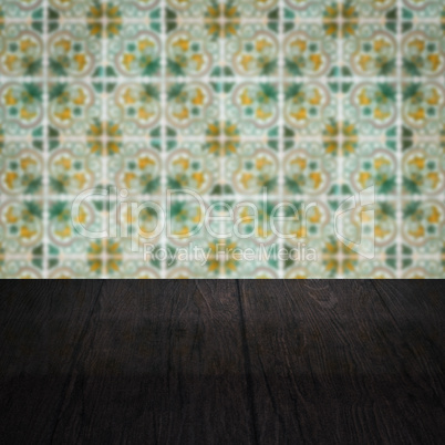 Wood table top and blur vintage ceramic tile pattern wall Wood table top and blur vintage ceramic tile pattern wall