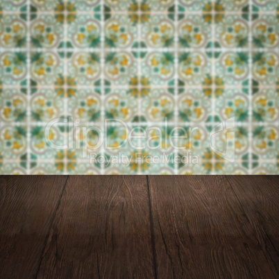 Wood table top and blur vintage ceramic tile pattern wall