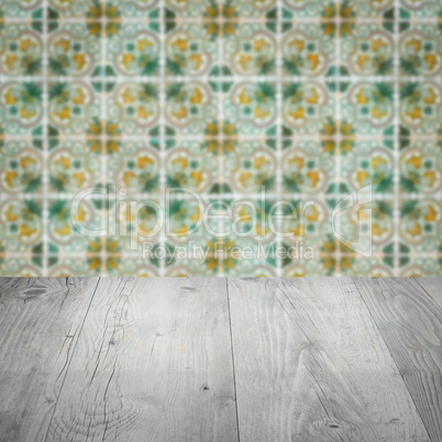 Wood table top and blur vintage ceramic tile pattern wall