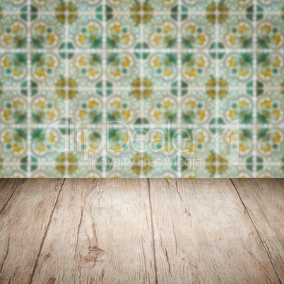 Wood table top and blur vintage ceramic tile pattern wall